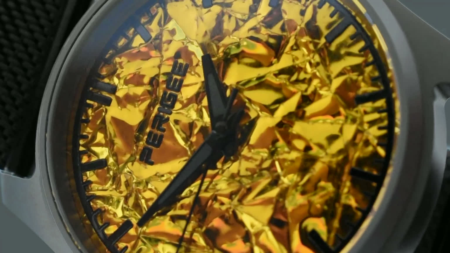 Photograph of the finished dial: aluminized foil under sapphire, the light broken into facets across its folds.