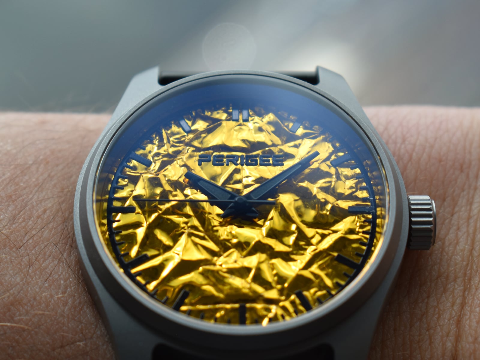The watch worn, the foil dial lit by daylight.